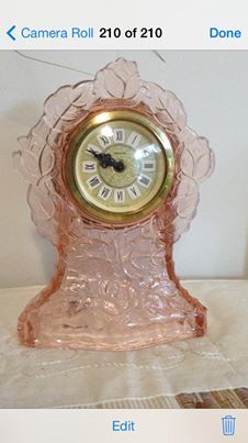 a pink glass clock sitting on top of a table