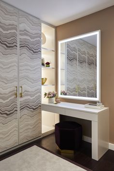 a dressing table with a mirror and stool in front of it, next to a white cabinet