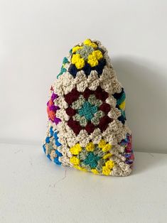 a crocheted purse sitting on top of a white table next to a wall