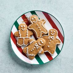 three ginger cookies on a plate with candy canes