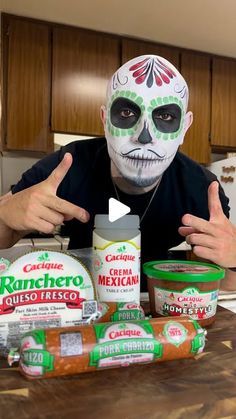 a man with face paint and mexican food on a kitchen counter in front of him