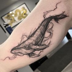 a man's arm with a whale tattoo on it