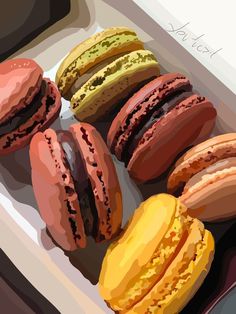 there are many different colored macaroons on the table