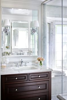 a bathroom with marble counter tops and white walls