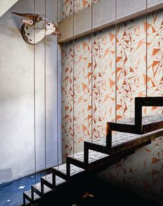 an artisticly designed room with stairs and wallpaper