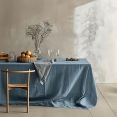 the table is covered with blue linens and has an empty chair next to it