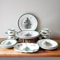 a table topped with plates and bowls filled with christmas tree decorations on top of a wooden table