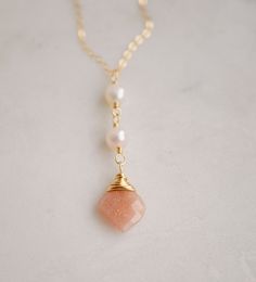 Classic. Elegant. Dressy or casual. This little necklace is made with a genuine faceted peach Moonstone and freshwater pearls on a gold fill or sterling silver chain. Peach Moonstone is known for aiding in the release of negative thinking and being overly self-critical. It's believed to be a stone of new beginnings, that brings balance and relief from emotional issues. The matching earrings are here.PENDANT LENGTH: 1.75" Pearl Necklaces With Faceted Detail As Gift, Peach Jewelry With Natural Stones For Gift, Peach Natural Stones Jewelry Gift, Peach Pearl Drop Jewelry As Gift, Peach Pearl Drop Jewelry Gift, Peach Pearl Drop Jewelry For Gift, Gold Faceted Pearl Necklace Gift, Peach Pearl Jewelry As Gift, Peach Pearl Jewelry For Gift