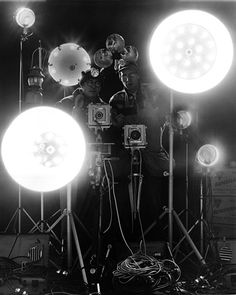 several lights are set up in front of a camera on a tripod and some other lighting equipment