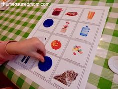 a child's hand is pressing buttons on a printable activity