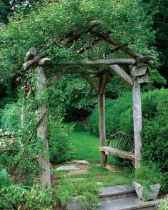 a wooden arbor with steps leading up to it in the middle of a lush green garden