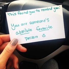 someone is holding up a note to someone in the car