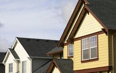 several different colored houses with brown roofs and white trim on the top one is yellow