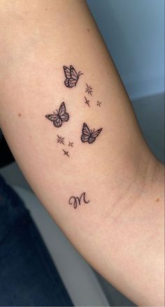 a woman's arm with three butterflies on it and the word mom written in cursive writing