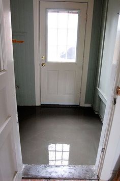 an open door leading to a white front door