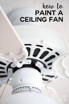 a white ceiling fan with black and white trim on it's blades hanging from the ceiling