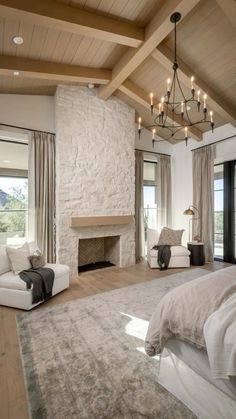 a large bedroom with a fireplace, couch and chair in it's center area