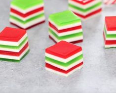 several pieces of candy sitting on top of a table next to each other with red, green and white frosting