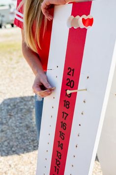 a woman is holding a sign with numbers on it