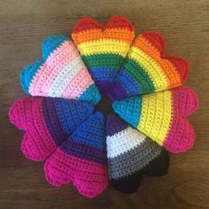 several crocheted mittens arranged in a circle on top of a wooden table