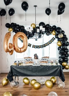 the table is set up with balloons and streamers