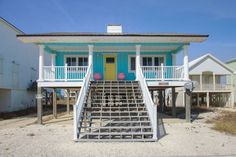 a blue and white house with stairs leading up to it