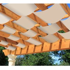 an image of a wooden pergoline roof with white sheets on the top and bottom