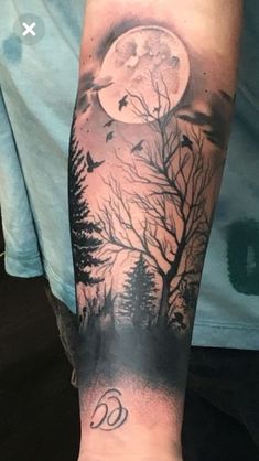 a person with a tattoo on their arm that has trees and birds flying in front of the moon