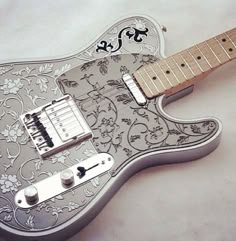 an electric guitar is decorated with flowers and scrolls