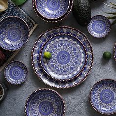 blue and white plates sitting on top of a table next to an avocado