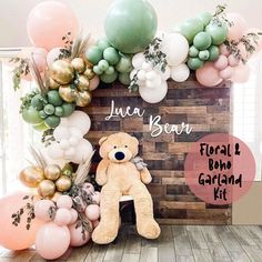 a teddy bear sitting in front of a bunch of balloons with the words julia bear floral and balloon garland kit