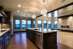 a large kitchen with an island in the middle and lots of windows on both sides