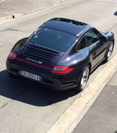 a black porsche parked on the side of the road