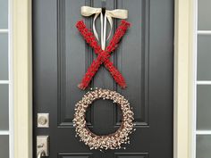 a black door with a wreath and bow hanging on it