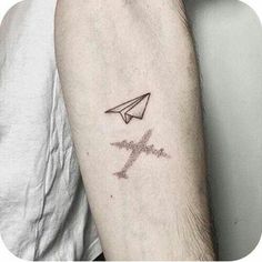 a man's arm with a small tattoo on it and an airplane in the middle