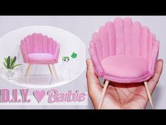 a hand holding a miniature pink chair with wooden legs