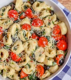 a white bowl filled with pasta and tomatoes