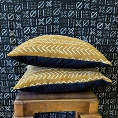 three pillows are stacked on top of each other in front of a black and white wall