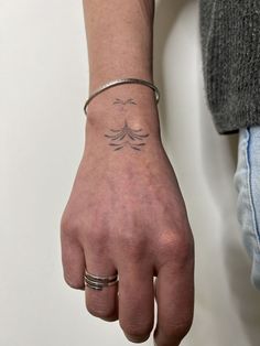 a person with a tattoo on their arm holding onto the wrist and wearing a bracelet