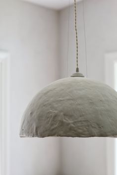 a white light hanging from a ceiling in a room