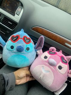 two stuffed animals sitting in the front seat of a car