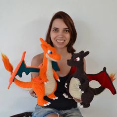 a woman holding three crocheted stuffed animals