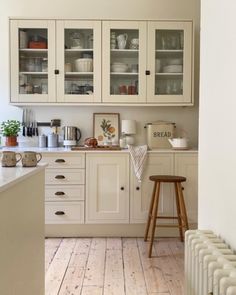 a kitchen with white cabinets and wooden floors