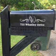 a black mailbox sitting on the side of a road