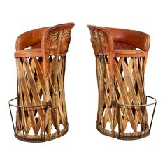 a pair of chairs made out of wood with leather seats on the back and sides