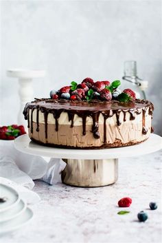 a cake with chocolate frosting and berries on top