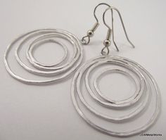 These earrings are so fun and sophisticated. They dress up any ensemble in no time. These earrings are lightweight and feature four matte silver plated circular wires that are finished off with stainless steel ear wires, for those with sensitive ears. The ear wires can be switched out to silver plated clip-ons, for those with non-pierced lobes. Simply select that option before adding to your cart. Height from top of ear wire to bottom of circles: 2 inches Width of circles: 1.25 inches Check the Silver Circle Earrings For Wedding, Perfume Making, Earrings Wedding, Keep Jewelry, Sensitive Ears, Bridesmaid Gift, Ear Wire, Chandelier Earrings, Natural Oils