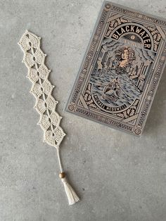 a book with a tassel on top of it next to a lace doily