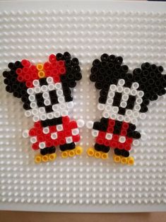 two mickey and minnie mouse earrings made out of legos