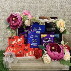 a basket filled with assorted chocolates and flowers